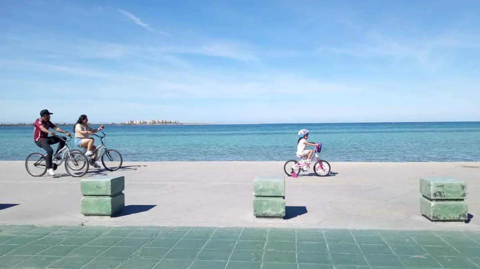 familia de paseo en bicicleta en el malecón